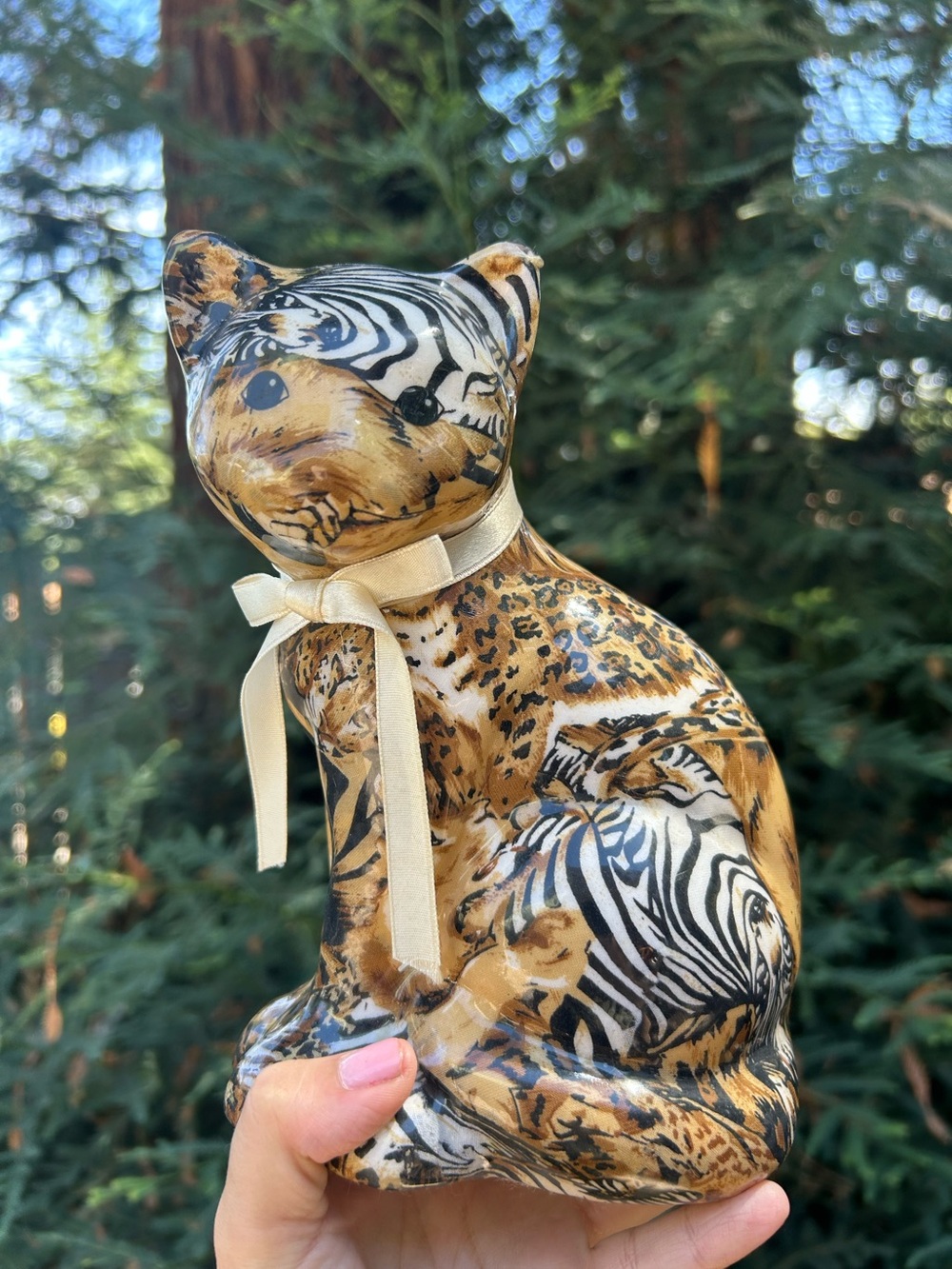 safari cat figurine featuring a mixed animal-print pattern with a cream-colored